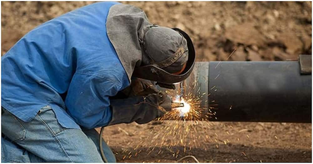 A metal worker joining a pipe.