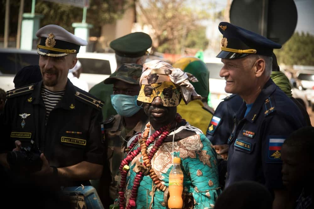 Russian military officers pose with a griot, a man in charge of singing praises, at a military parade in Mali