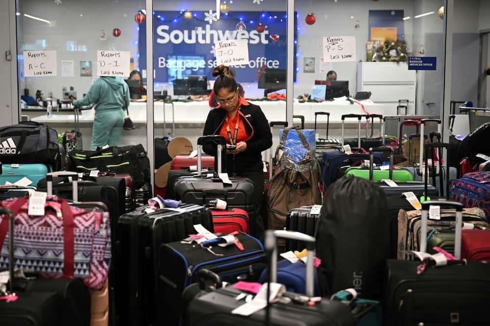 A Southwest Airlines ground crew member, photographed on December 28, 2022, is shown organizing unclaimed luggage at Los Angeles International Airport