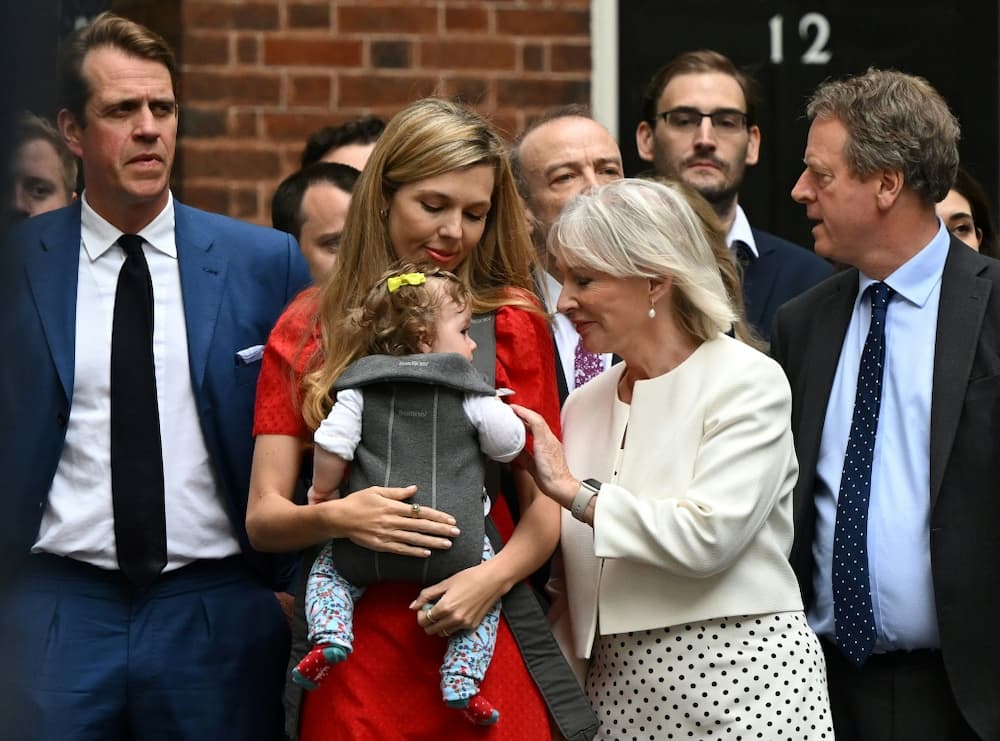 Johnson's wife Carrie, carrying their daughter Romy, watched his speech, flanked by Culture Secretary Nadine Dorries and Downing Street staff