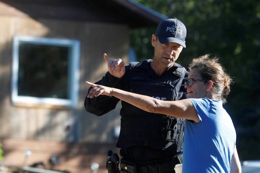 Ruby Works, a friend of a victim, speaks to a Royal Canadian Mounted Police officer in Weldon, Saskatchewan after the stabbing spree