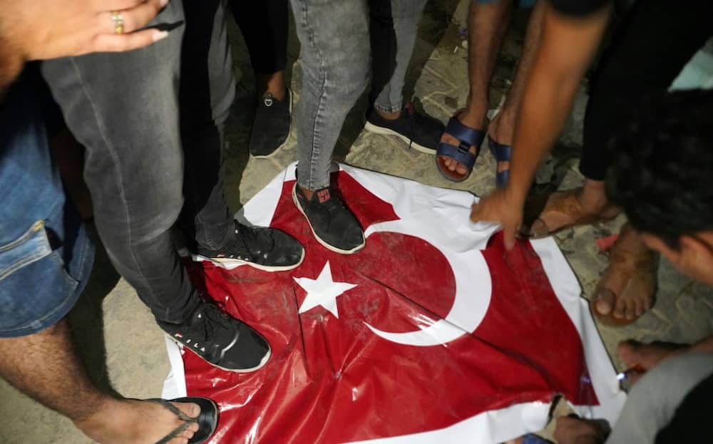 Iraqi protesters trample on a Turkish flag outside the consulate in the Shiite shrine city of Najaf, angry at the deaths of nine people in what the government says was Turkish shelling of a Kurdish hill village