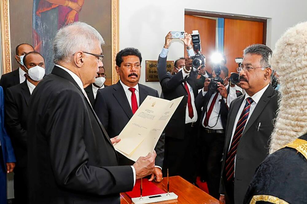 A handout photo released by the Sri Lanka's parliament shows president-elect Ranil Wickremesinghe (front R) being sworn in