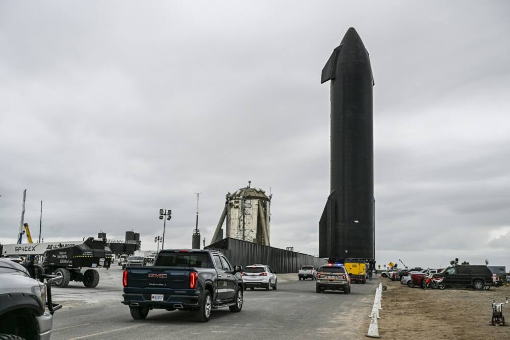 People gather as SpaceX Starship spacecraft prototype is transported from the launch site ahead of the SpaceX Starship third flight test from Starbase in Boca Chica, Texas
