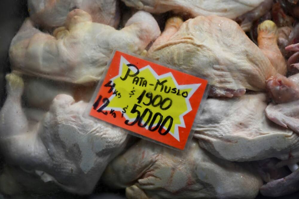Chickens are seen with a sign indicating their price in Argentine pesos at the Central Market in Buenos Aires on May 12, 2023