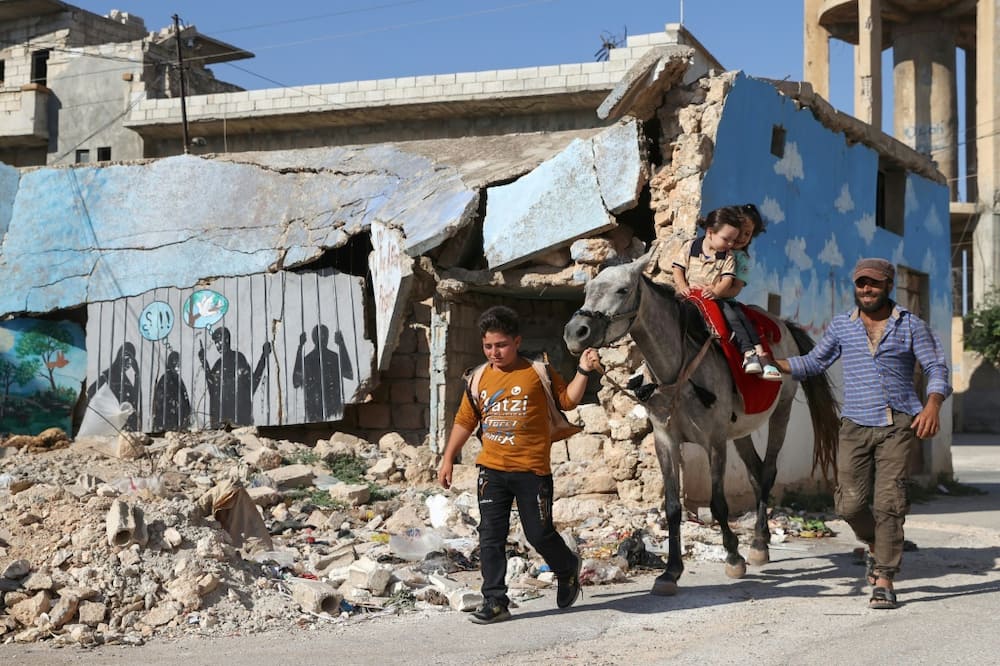 Children take a donkey ride during Eid al-Adha celebrations in Syria's rebel-held Idlib province on July 9, an area reliant on UN aid brought across the border from Turkey