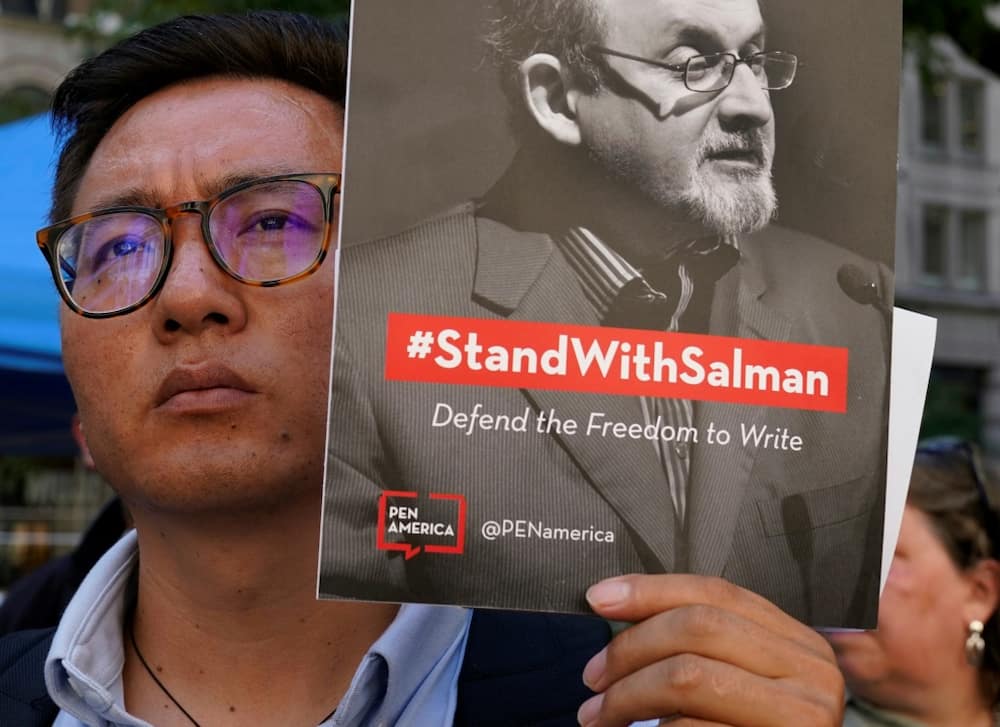 Supporters wield signs promoting freedom of speech at a rally after Salman Rushdie's attack