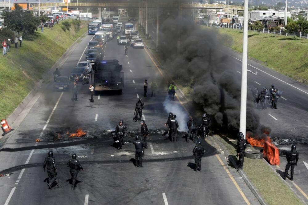 Riot police clear a blockade on the highway to Quito airport, one of Ecuador's indigenous-led protests against high fuel prices and living costs, on June 17, 2022