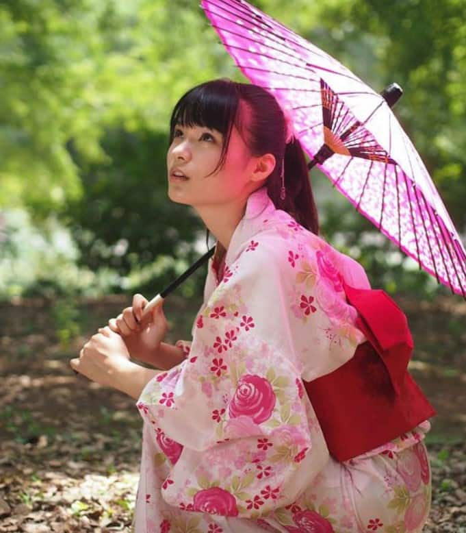 A woman dressed in the traditional geisha style wearing a kimono and obi  with an elaborate