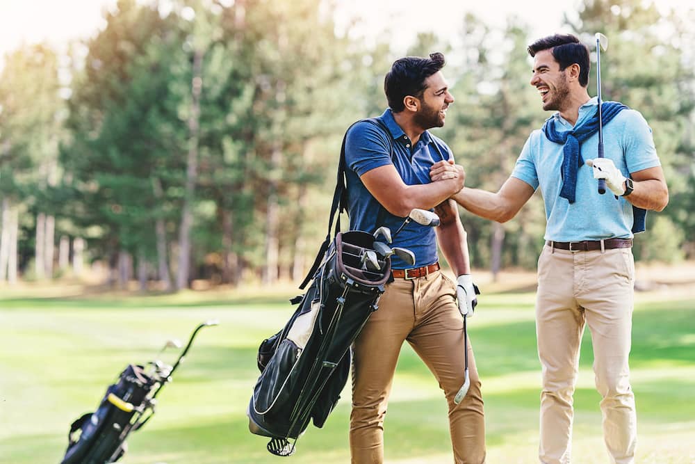 Two golf players greet each other on the field