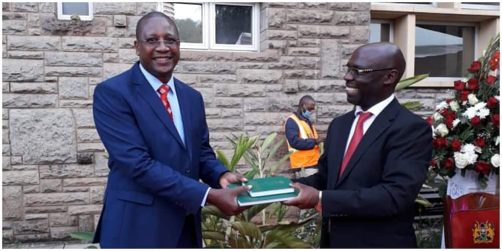 Prof Mwangi Iribe who led the team of experts receiving copies from Arap Kirui who lead the Parliamentary Team. Photo: National Assembly.