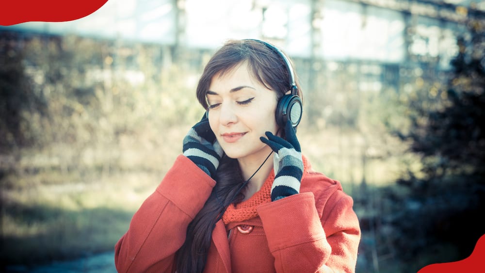A woman is listening to music in headphones while walking