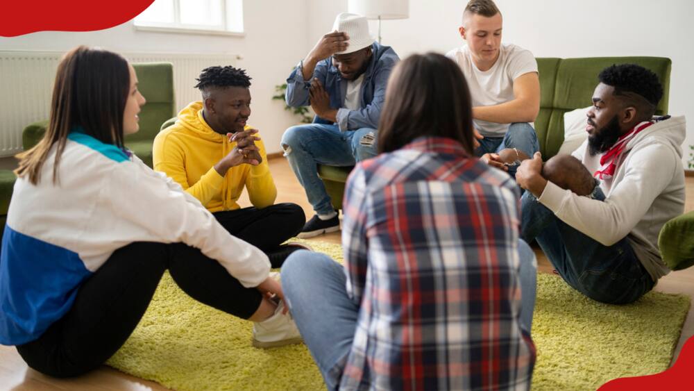 A group of people sitting in a circle are having a discussion